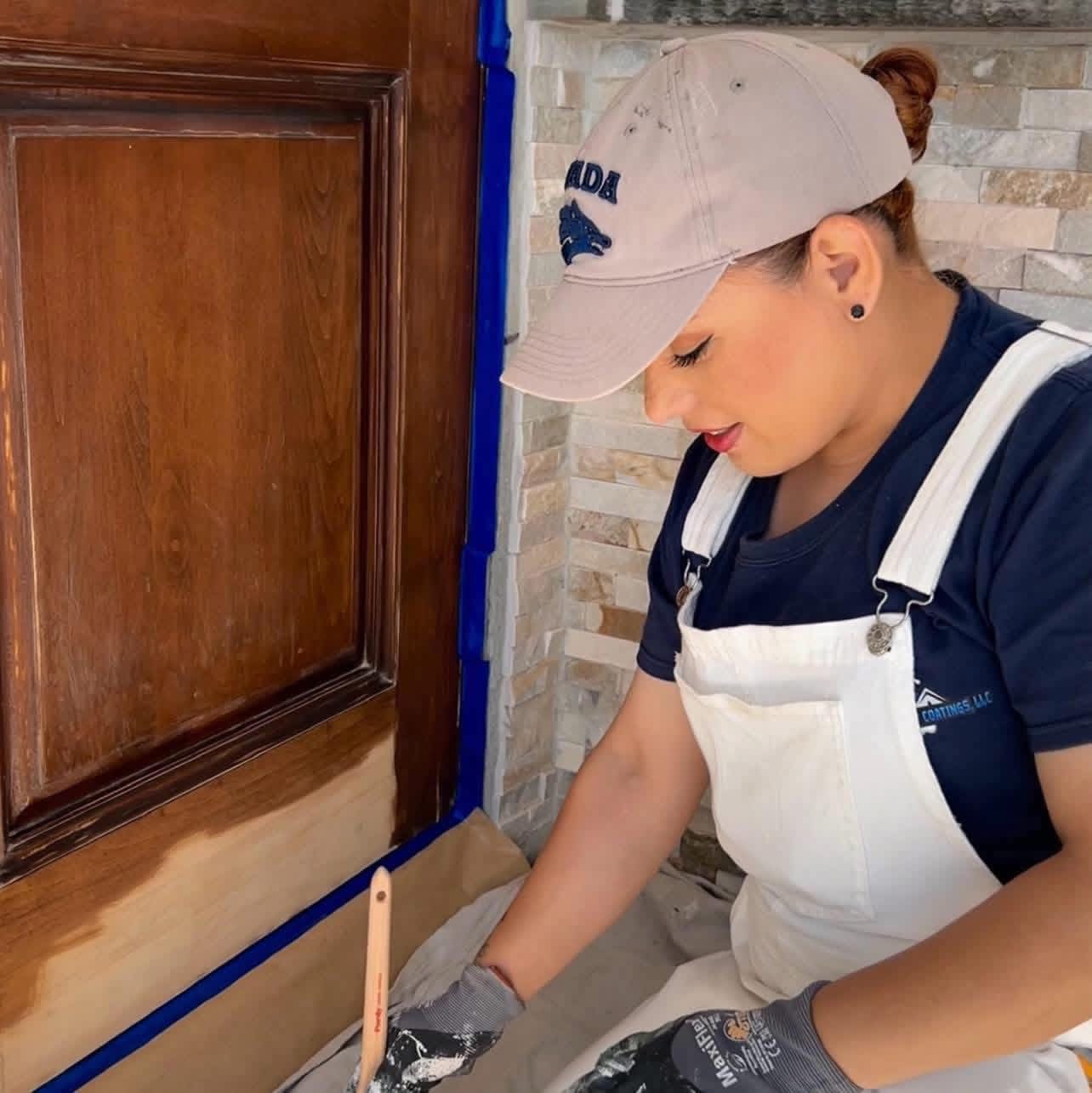 Hand-staining a wood entry door, taped and protected — Reno